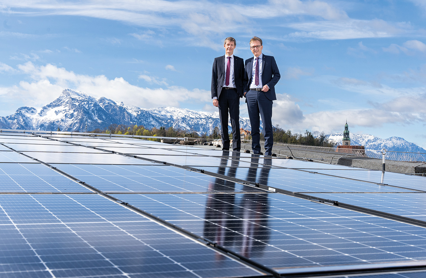 Vorstand steht neben Photovoltaikanlage auf Dach