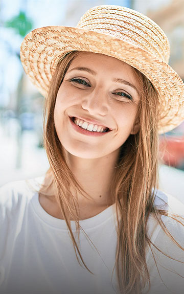  Junge Frau mit Sonnenhut auf der Straße 