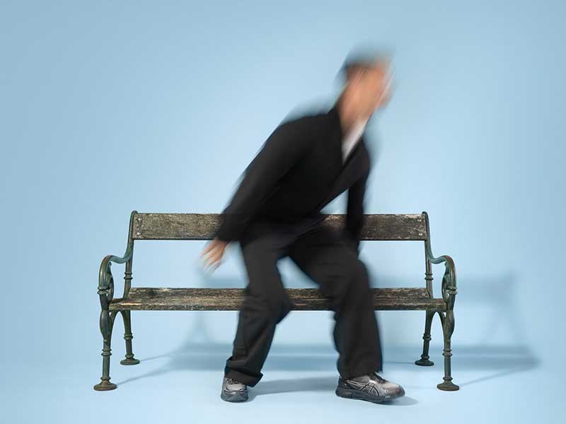 Mann steht von alter Bank auf