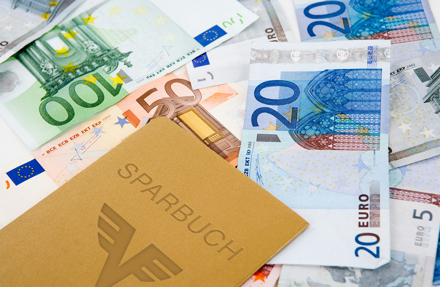 Bild von einem goldenen Sparbuch auch verschiedenen Banknoten liegend