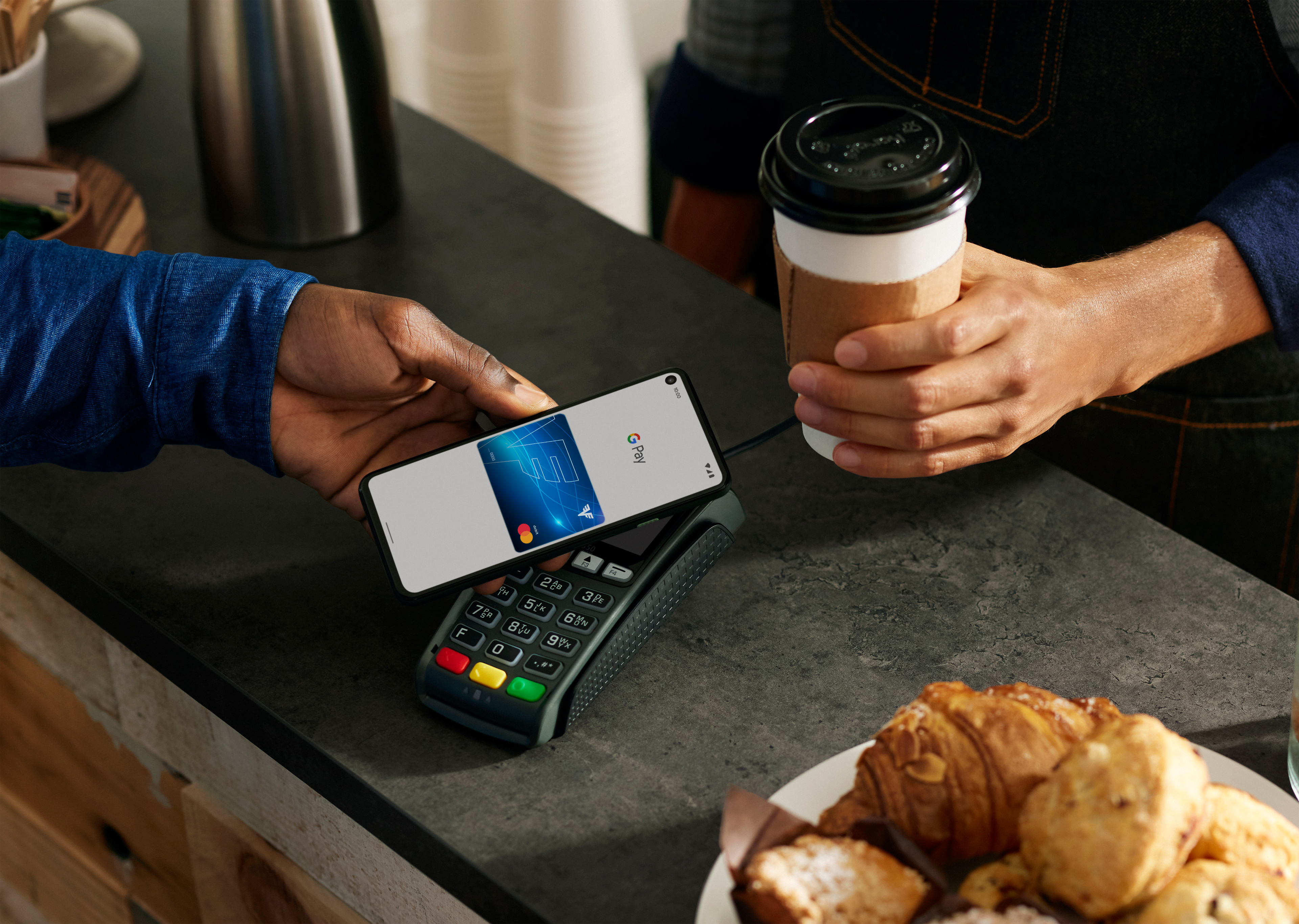 Google Pay wird auf einem Handy in einem Café zum Bezahlen genutzt.