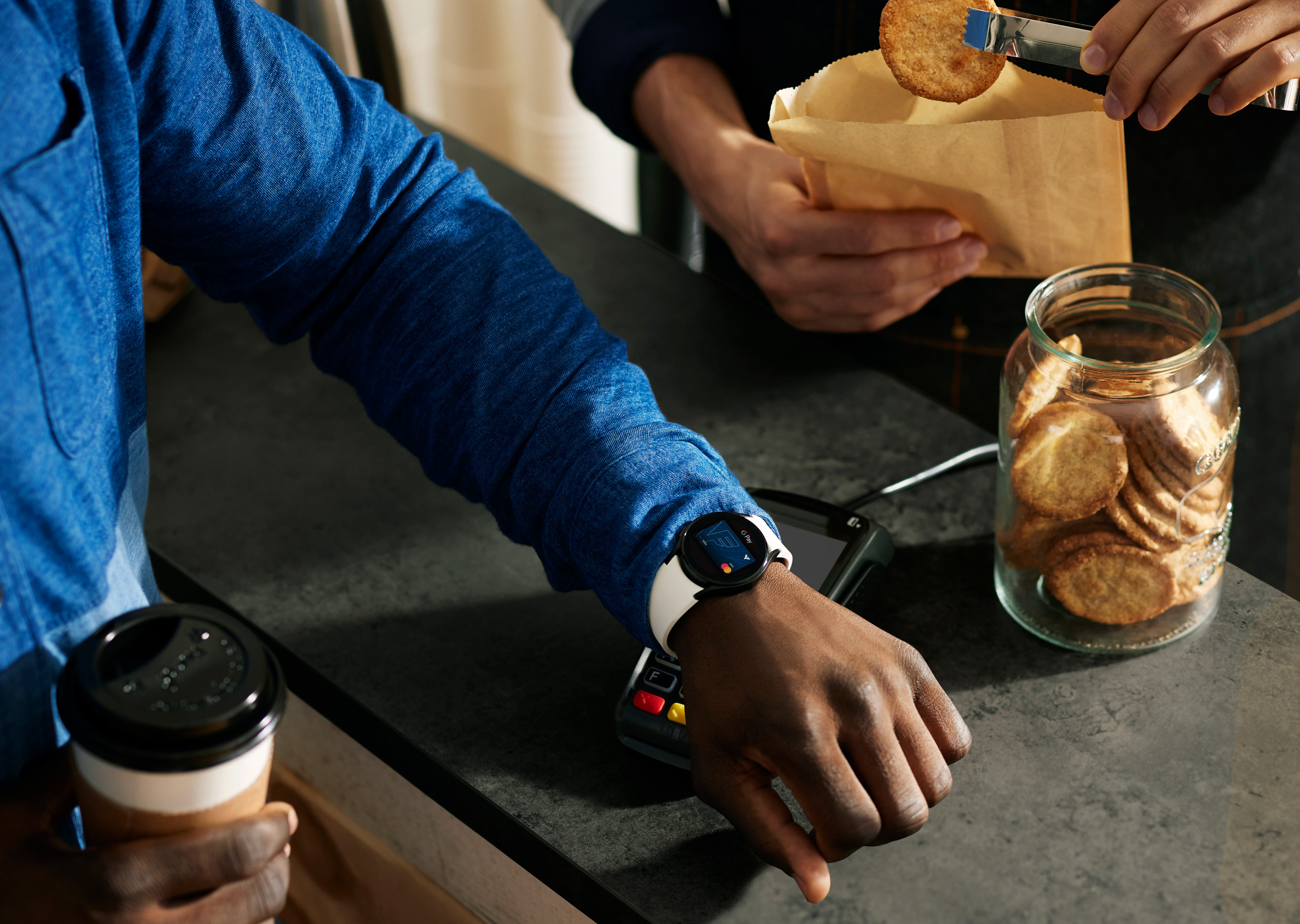 Ein Mann zahlt mit Google Pay am Handy in einem Café.
