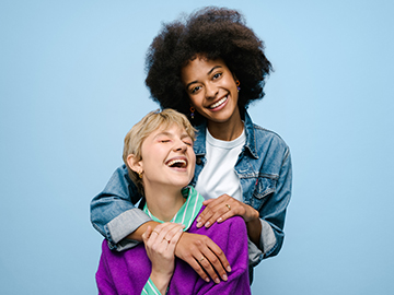 Zwei Mädchen lachen und umarmen sich