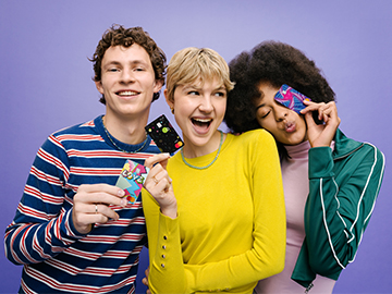 Drei junge Menschen halten Volksbank Debit Mastercards in der Hand.